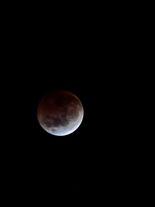 My first image of a lunar eclipse! This depicts the moon with the upper three quarters tinted red by a lunar eclipse and the bottom crescent white.