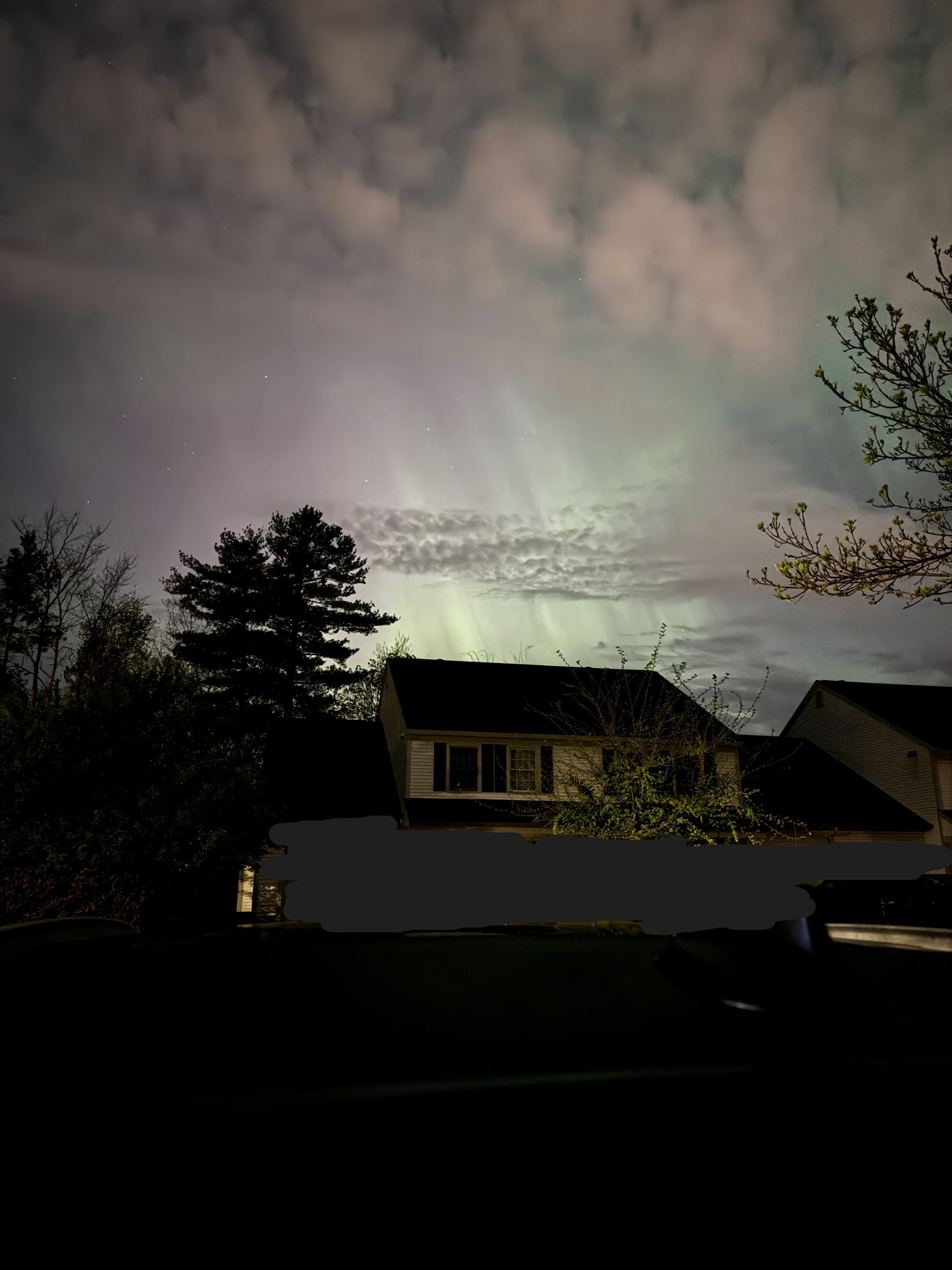 The Northern Lights! I don't get these very often where I live. This depicts the Northern Lights above a house and trees.