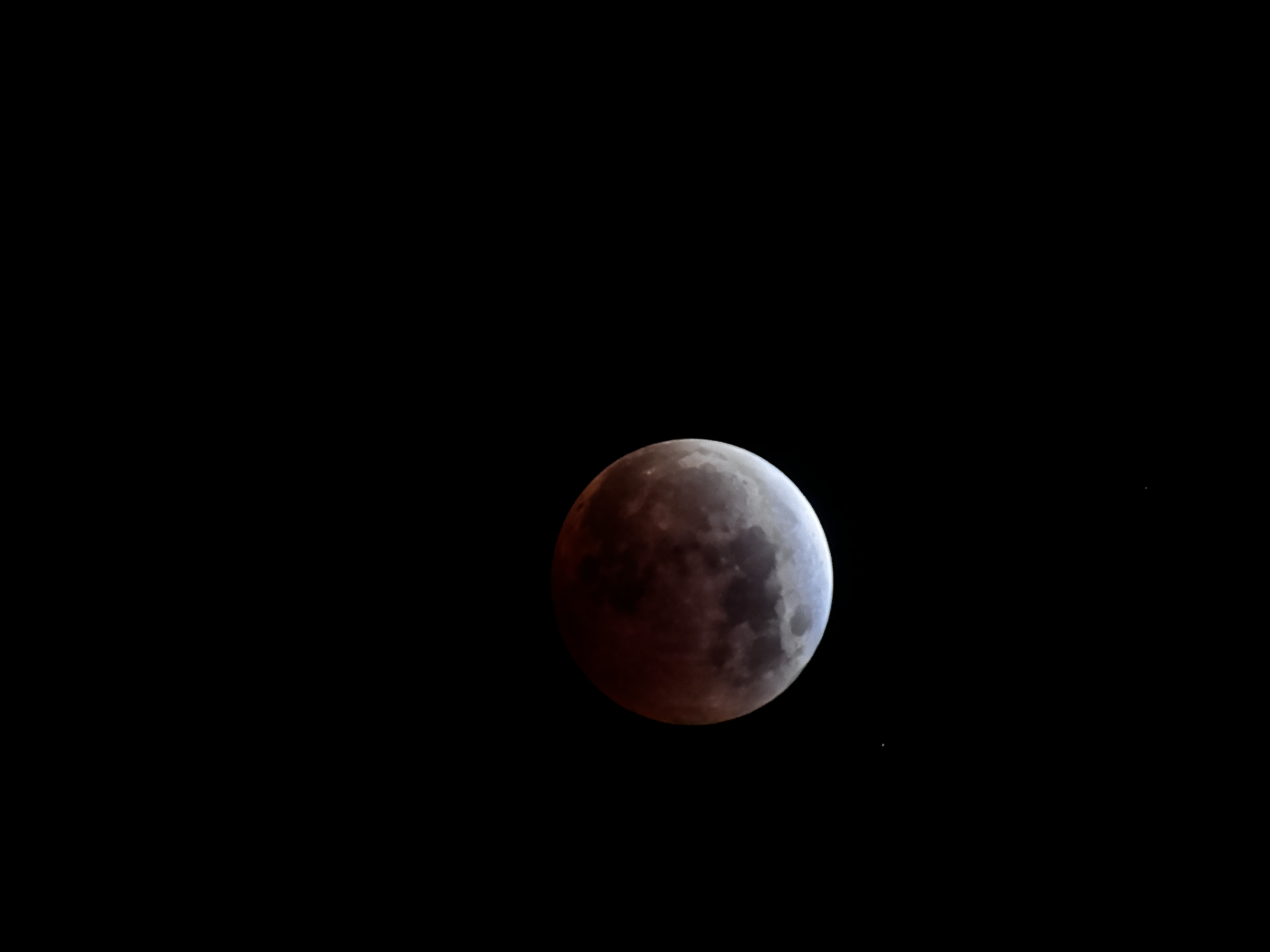 My first image of a lunar eclipse! This depicts the moon with the upper three quarters tinted red by a lunar eclipse and the bottom crescent white.