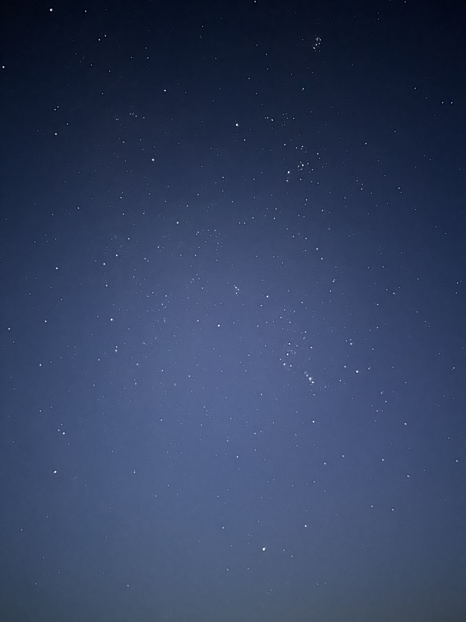This is a wide angle shot of the sky, it contains the Pleiades Cluster in the top right! This image depicts many stars in a bright sky.